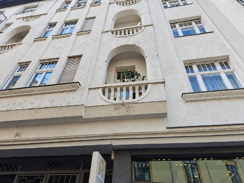 A klasszikus belvárosi lakóépület homlokzata íves erkélyekkel