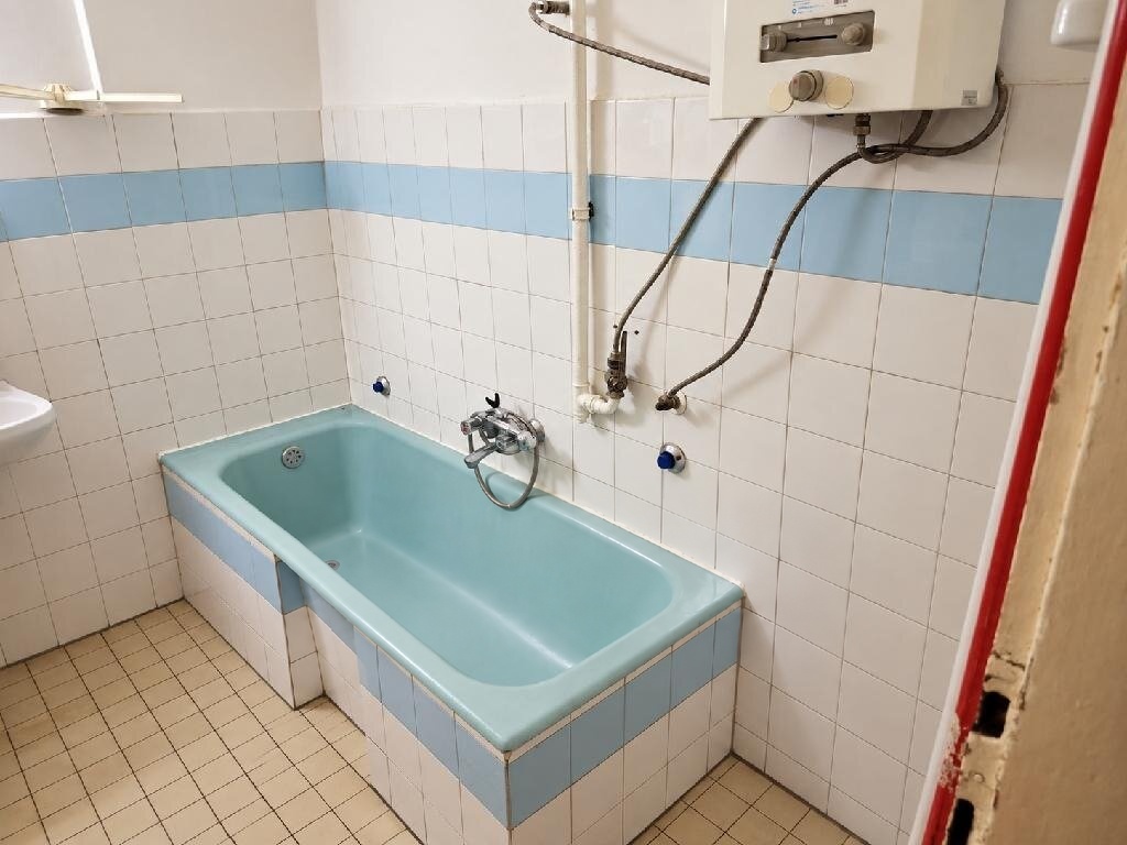 Felújítandó fürdőszoba káddal, mosdóval és ablakkal
