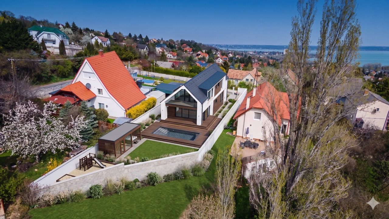 Látványterv: modern családi ház drónfelvétele medencével, kerttel és balatoni panorámával
