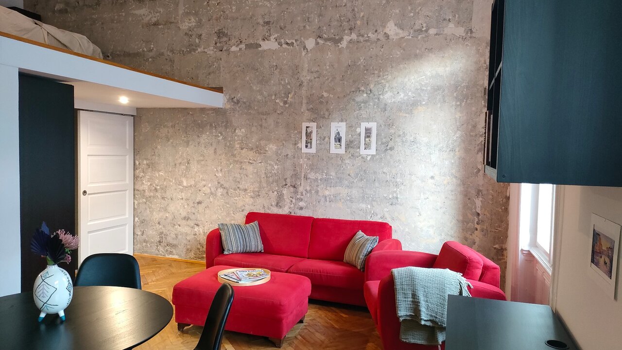 Loft nappali galériaággyal és betonfallal
