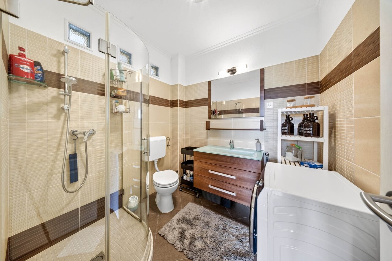 Fürdőszoba zuhanykabinnal, mosdóval, WC-vel és mosógéppel