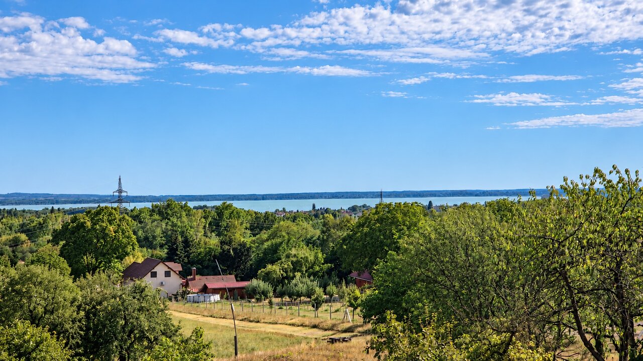 Kilátás a Balatonra és a zöldellő, gyümölcsfás tájra