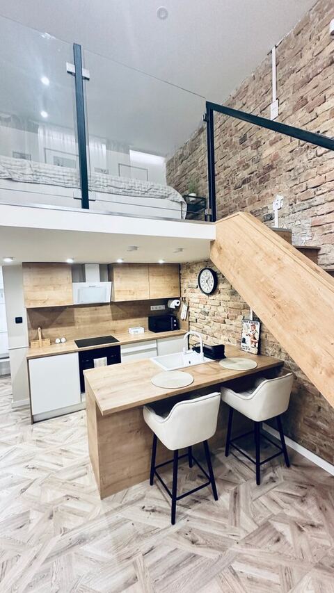 Loft stílusú konyha a galéria alatt, exponált téglafallal