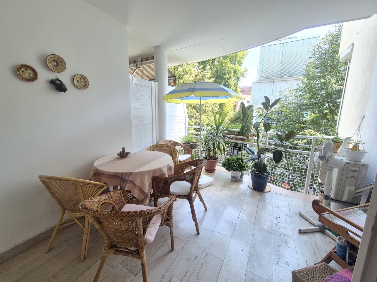 A lakás 9,5 m²-es fedett terasza kerti bútorokkal és növényekkel