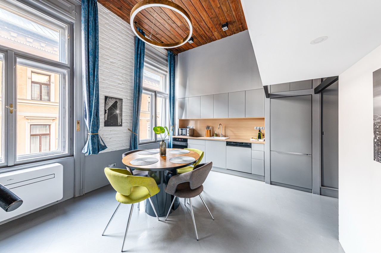 Modern loft konyha étkezővel, beépített gépekkel és fa mennyezettel