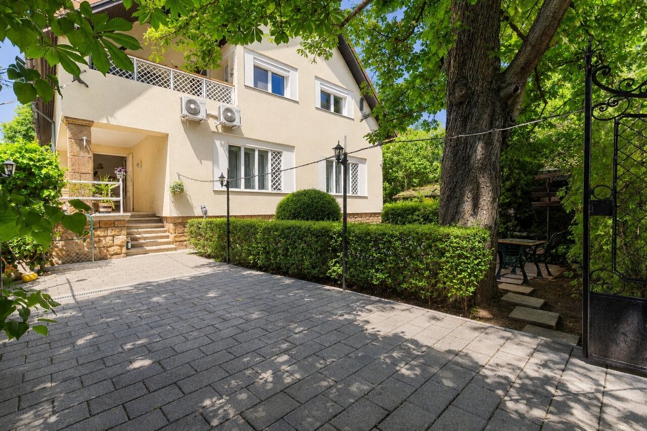 A villa homlokzata térkövezett beállóval