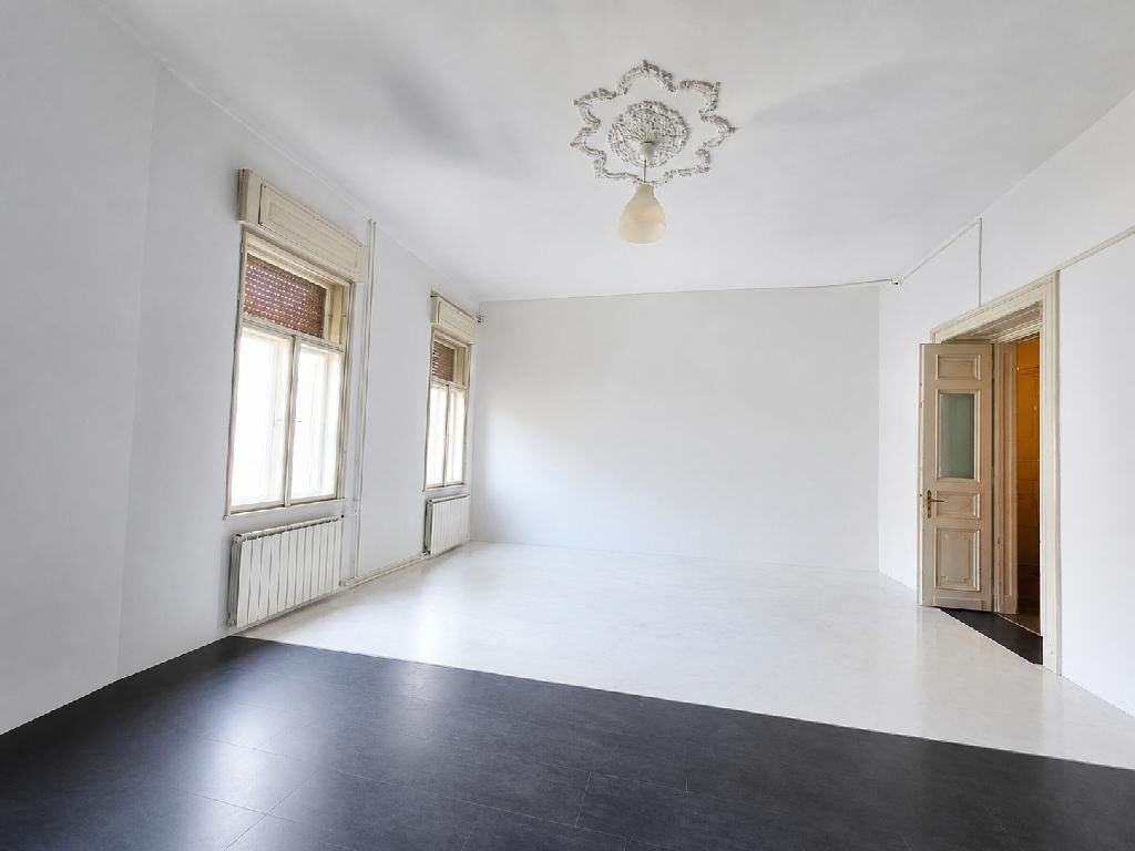 Világos, tágas, 138 m²-es lakás egyik szobája stukkós mennyezeti rozettával és nagy ablakokkal a Palotanegyedben