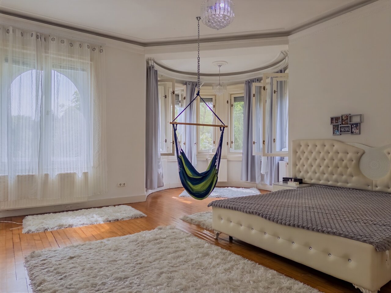 Modern, világos hálószoba steppelt ággyal, függő hintával, csillárral és parkettával - eladó luxusvilla, Budapest XII. kerület