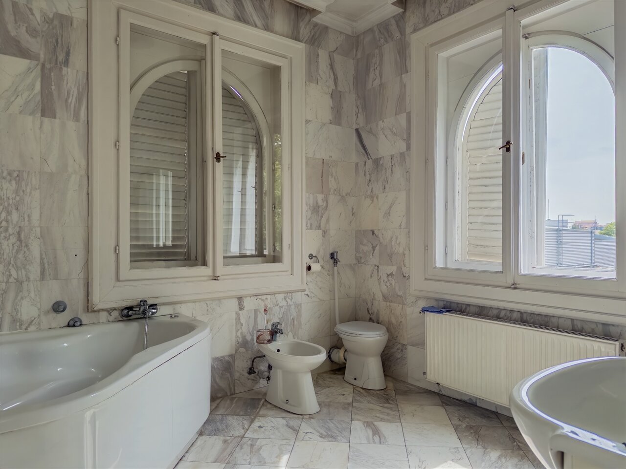 Tágas márványburkolatú fürdőszoba nagyméretű íves ablakokkal, káddal és bidével - eladó luxusvilla, Budapest XII. kerület
