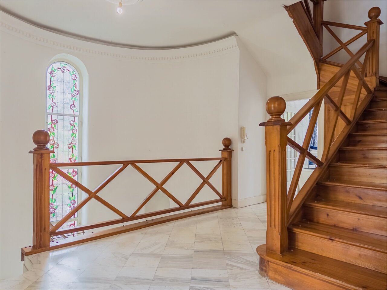 Világos lépcsőház elegáns falépcsővel, színes ólomüveg ablakkal és márványpadlóval - luxusvilla a Városmajorban, XII. kerület