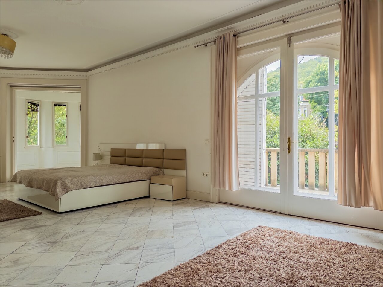Tágas hálószoba márványpadlóval és nagy erkélyajtókkal, zöld kilátással - luxusvilla a Városmajorban, XII. kerület