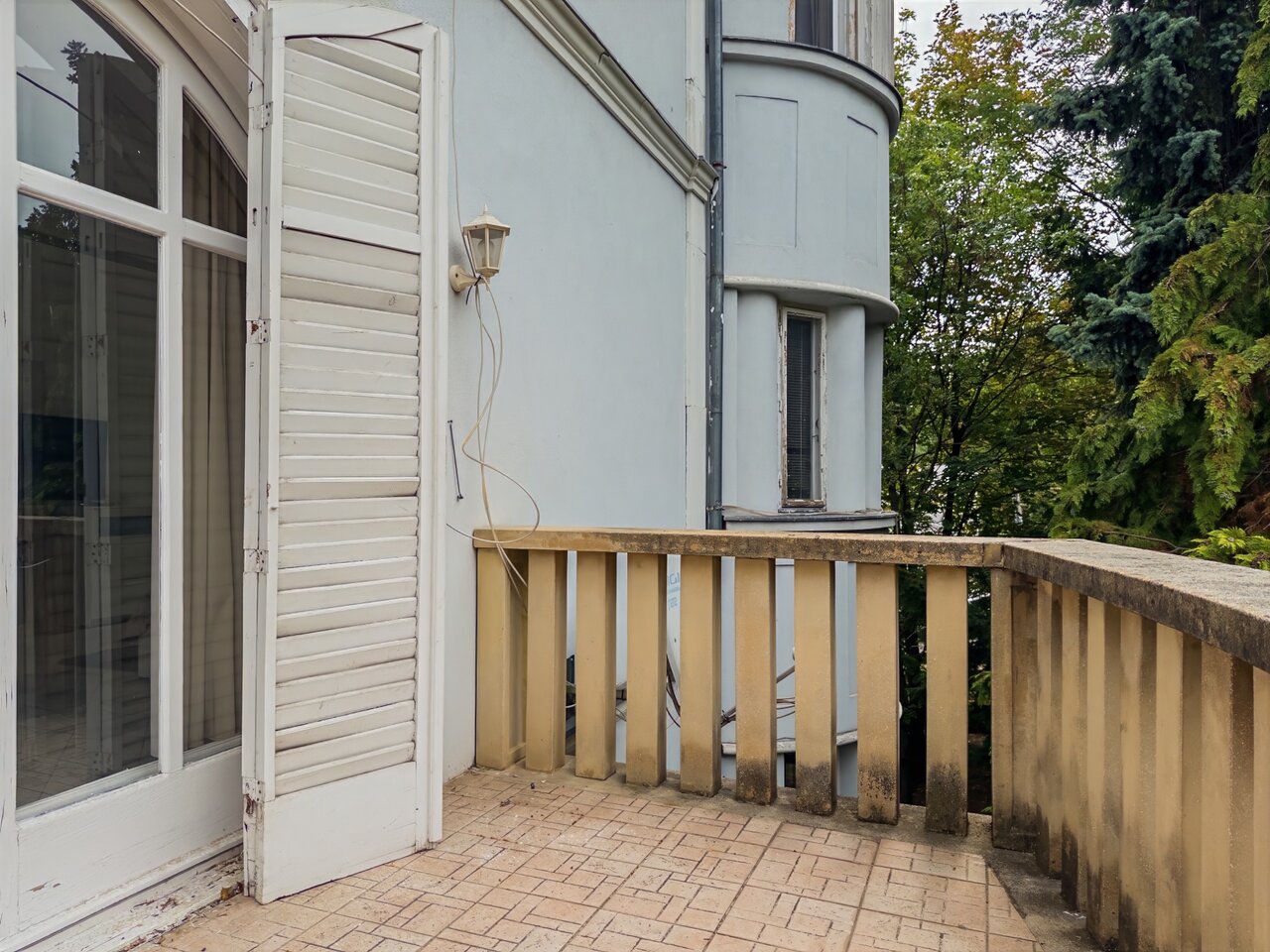 Klasszikus terasz kockakő burkolattal, beton korláttal és zsalugáteres ablakokkal - luxusvilla a Városmajorban, XII. kerület
