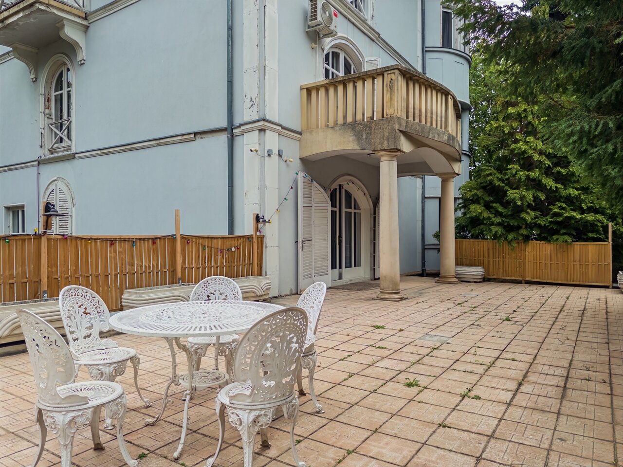Tágas burkolt terasz klasszikus öntöttvas kerti bútorokkal a villa mellett - eladó luxusvilla, Budapest XII. kerület